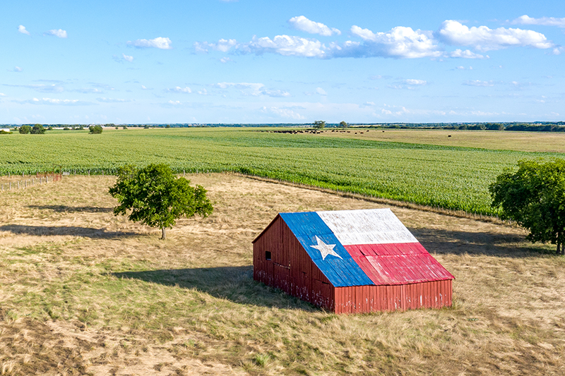 barn-with-texas-flag Barn adorned with the Texas flag, reflecting pride in rural heritage and connectivity.