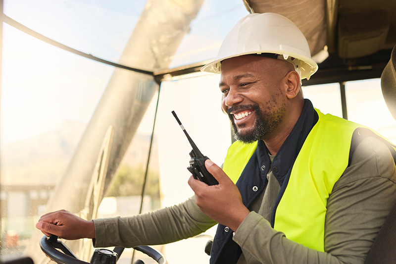 Man communicating via two-way radio, illustrating reliable rural communication methods.