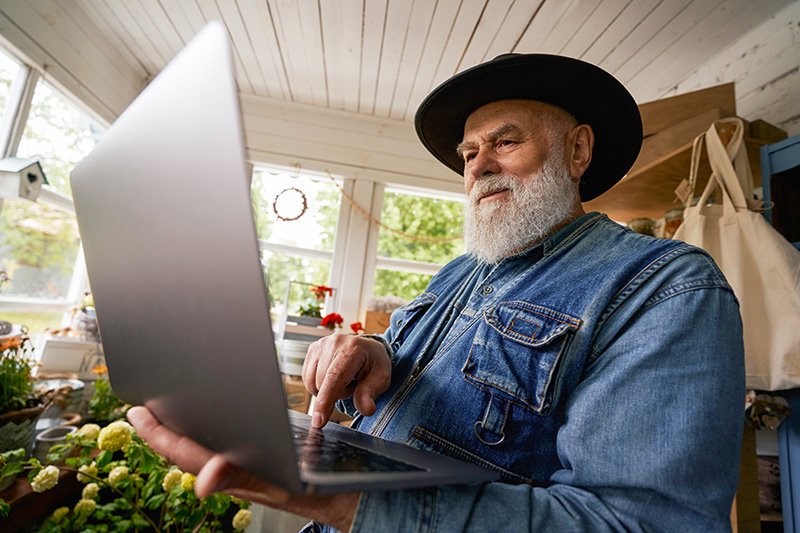 Man working on a laptop in a farmhouse, demonstrating reliable internet in remote locations.